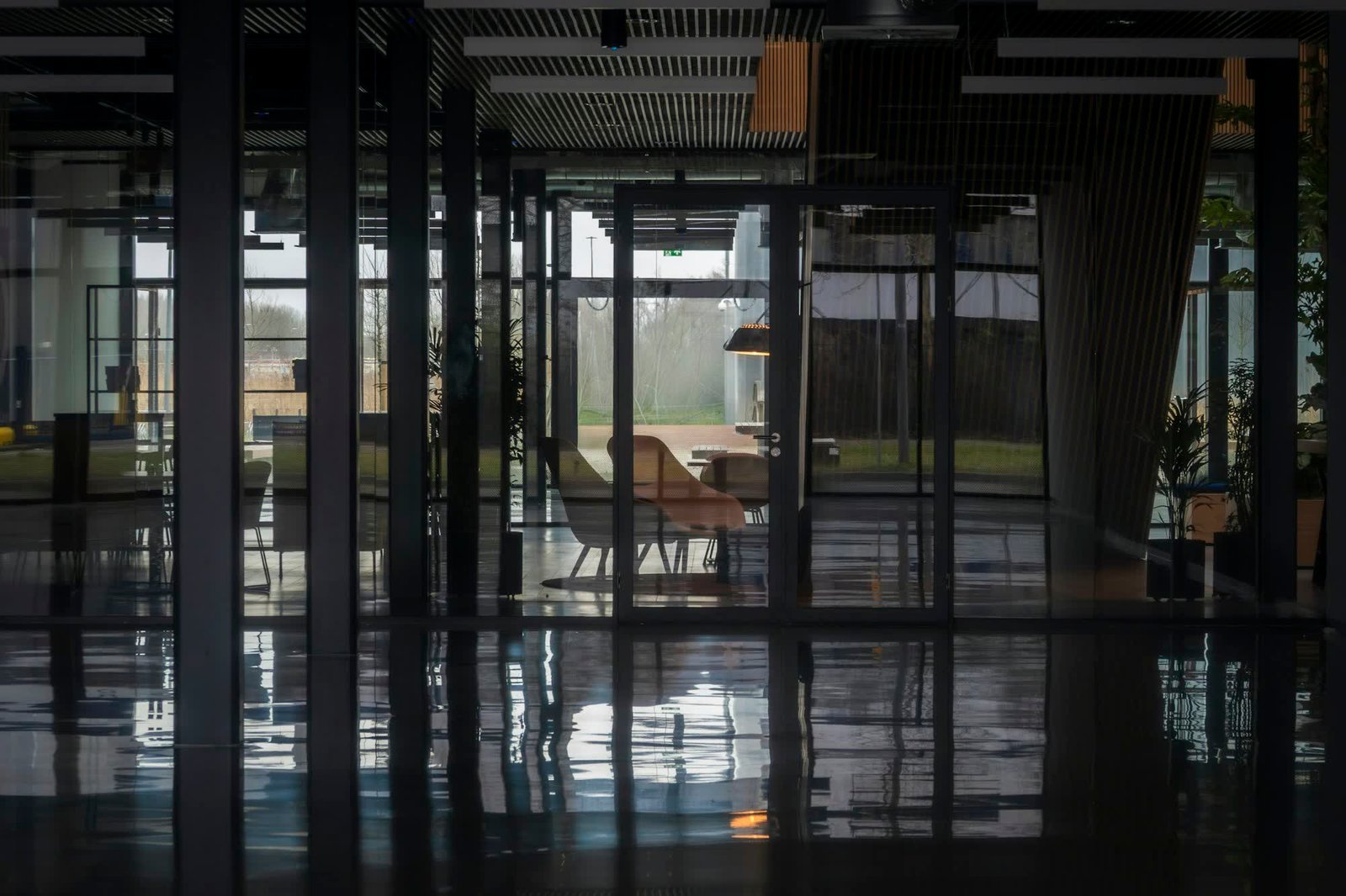 Glass office walls reflected in a polished floor