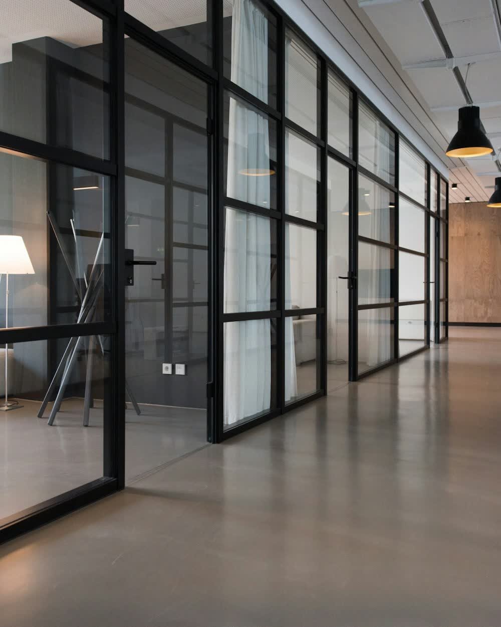 A bright office corridor with glass partitions