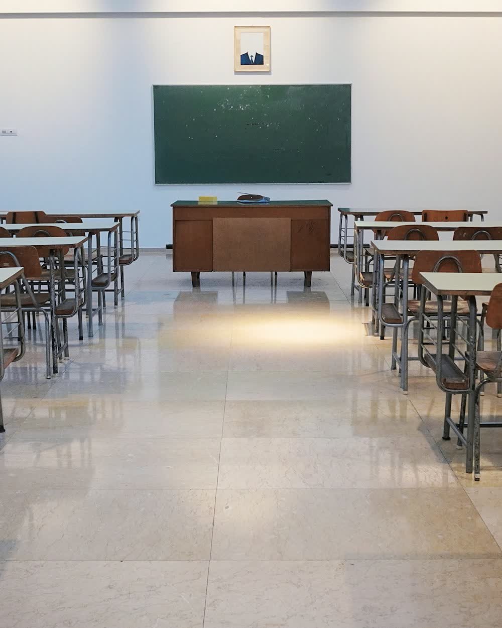 An empty classroom with rows of desks