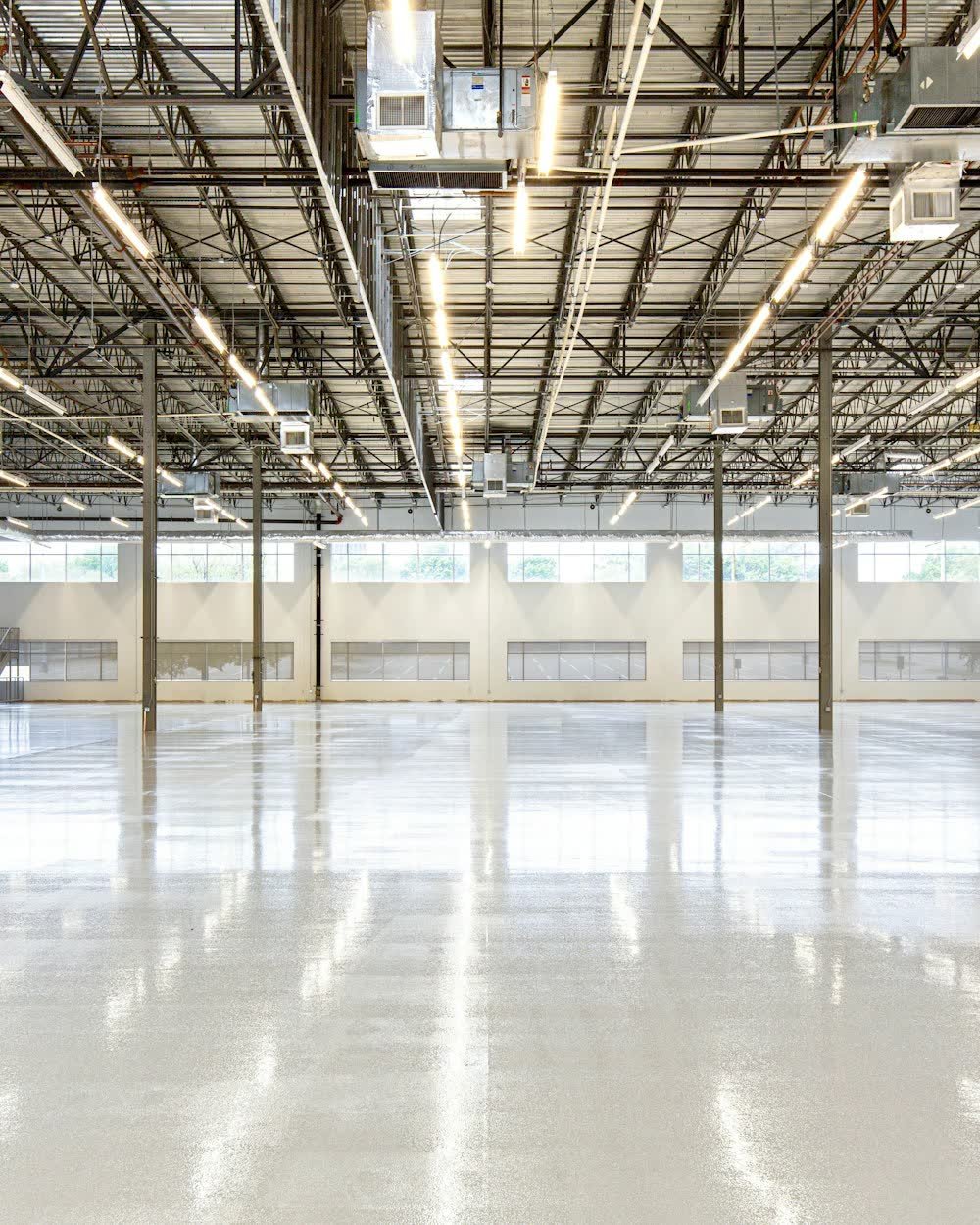 An empty warehouse with a polished concrete floor